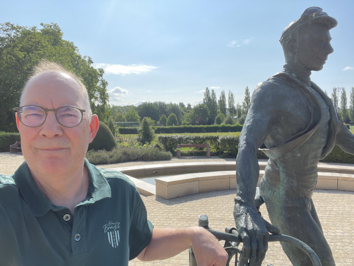 Henk van Eldik naast het standbeeld van de Luxemburgse wielrenner Charly Gaul.