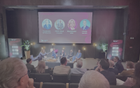 De bal ligt bij het publiek: dagvoorzitter Hanne Decoutere gooit de microfoonkubus de zaal in tijdens de Asset Class Battle op Portfolio Day 2026 in Brussel.
