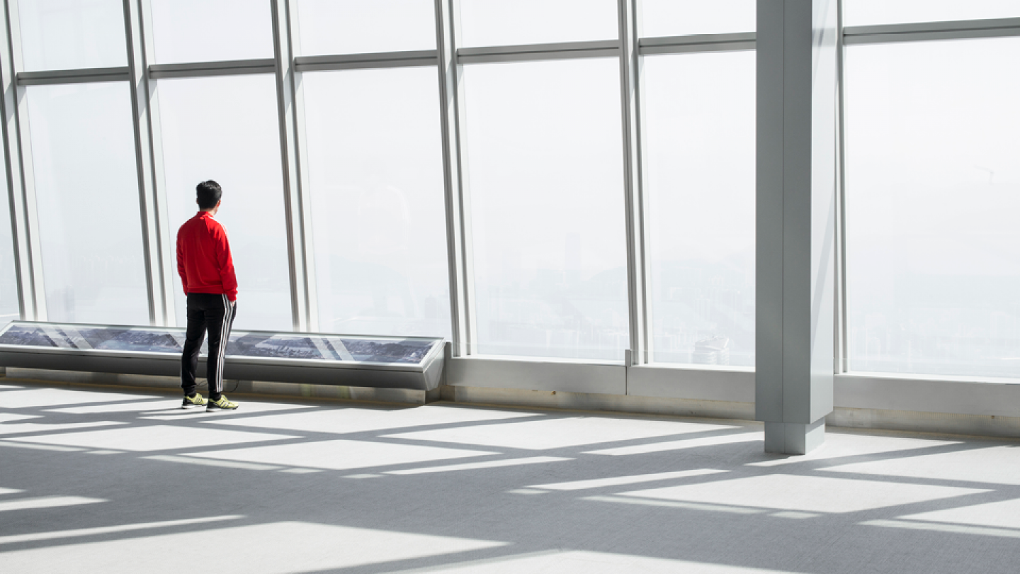 Man looking out of window in office building