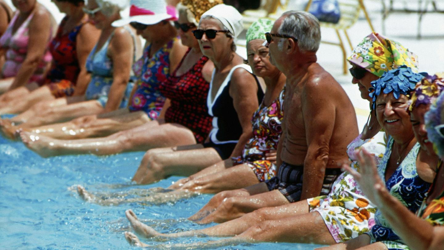  A group of people sitting next to each other in a swimming pool