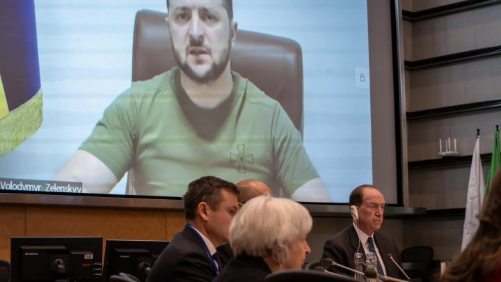 Ukrainian President Volodymyr Zelenskyy is seen speaking on a screen above World Bank Group President David Malpass at the World Bank Group 2022 Spring Meetings Ministerial Roundtable for Support to Ukraine on 21 April 2022. Photo: Paul Blake / WorldBank