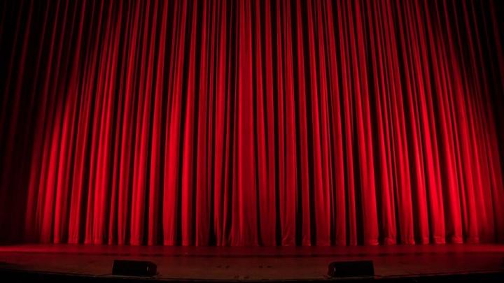 Stage with red curtains. Image CC via Flickr.