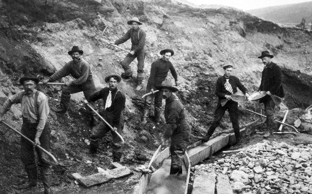 Miners at work with picks and shovels during the 19th century gold rush in Klondike, Alaska.